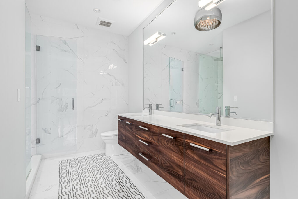 A bathroom with a wood cabinet, marble shower, and pattern tile floor. painted bathroom
