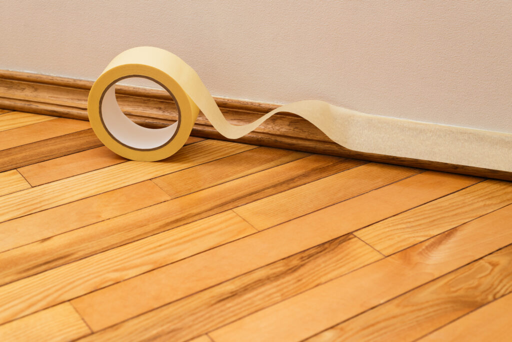 Sticking masking tape to the baseboard painter's tape